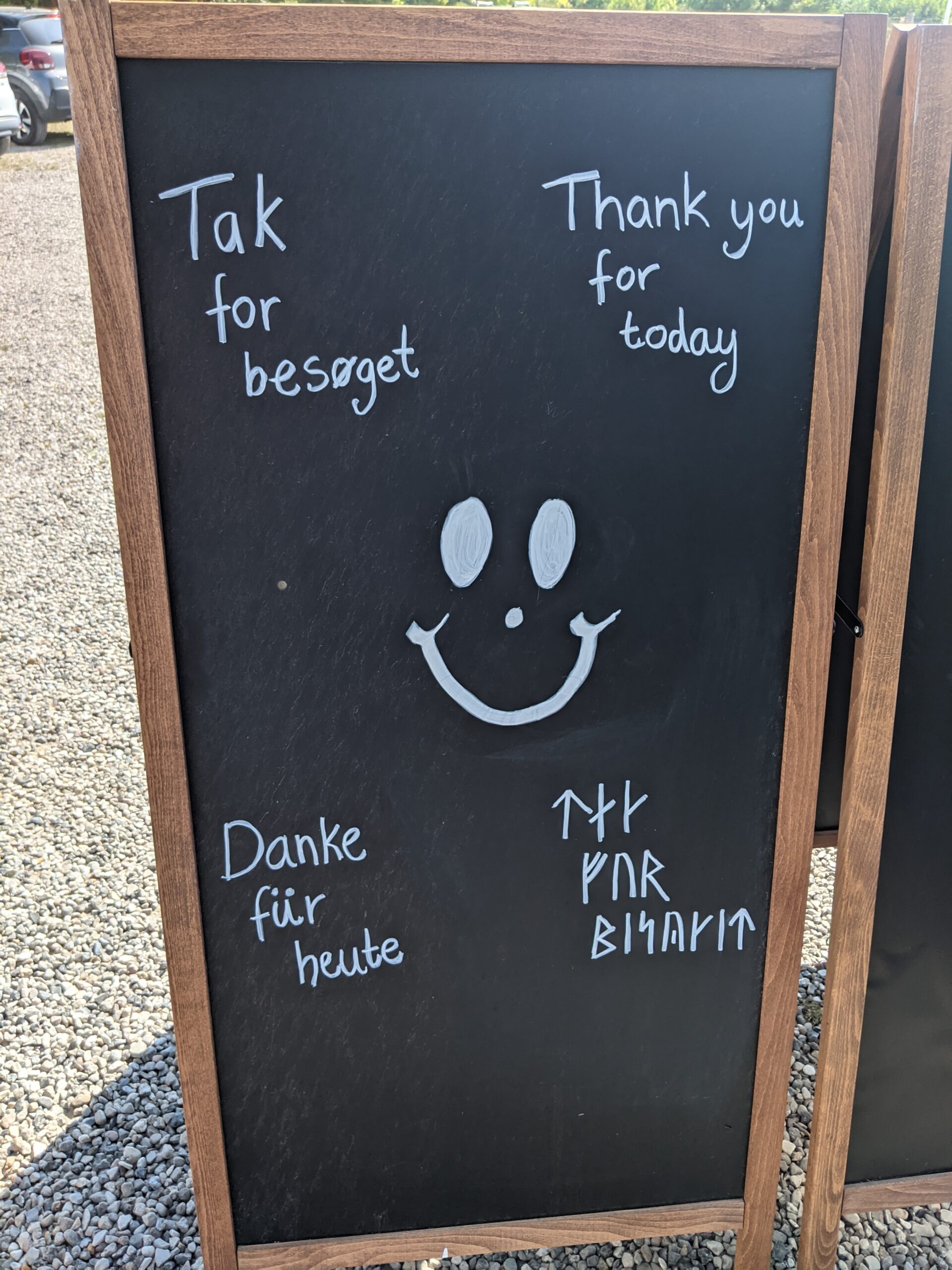 A sign that says "Thank you for today" in Danish, German, English and in runes