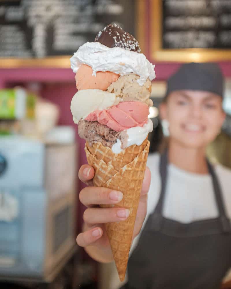 happy employee serves ice cream with 8 half balls